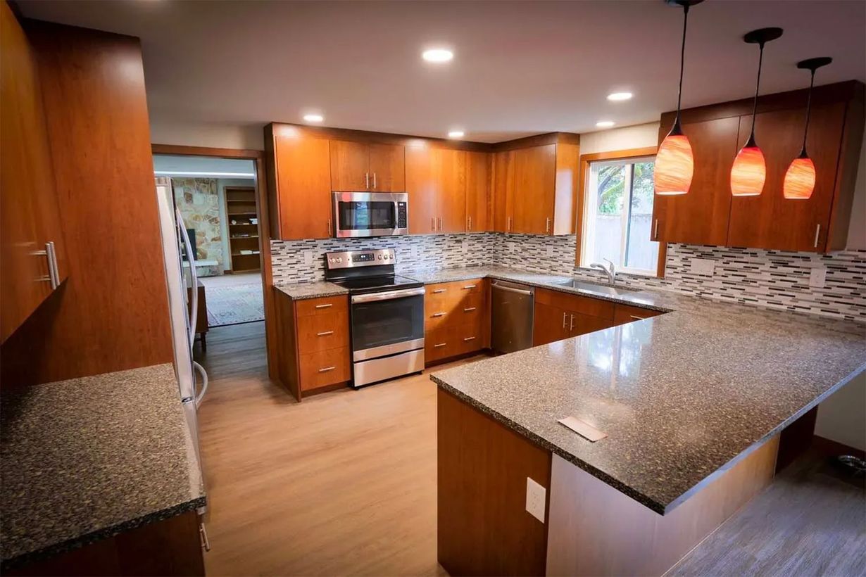 Modern kitchen with wood cabinets, granite counters, stainless appliances, and pendant lights
