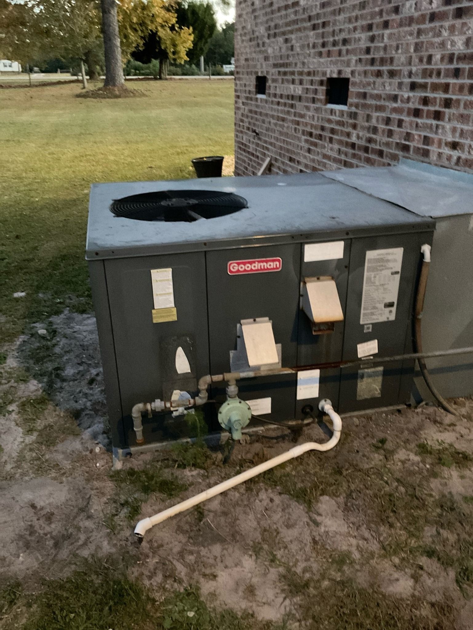 An air conditioner is sitting on the side of a brick building