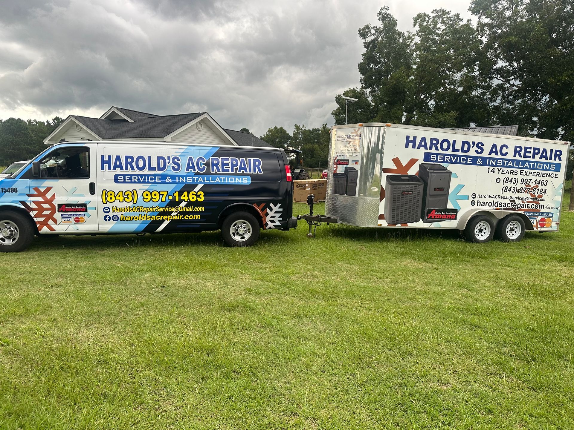Two harold 's ac repair vans are parked next to each other in a grassy field.
