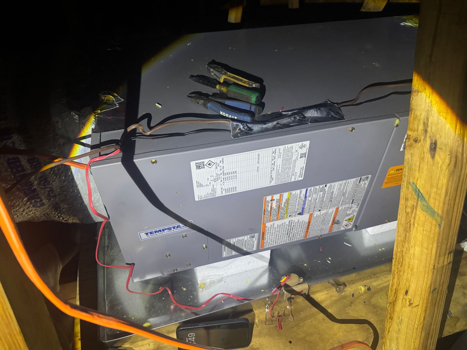 Open electronic device with exposed wires inside a wooden enclosure