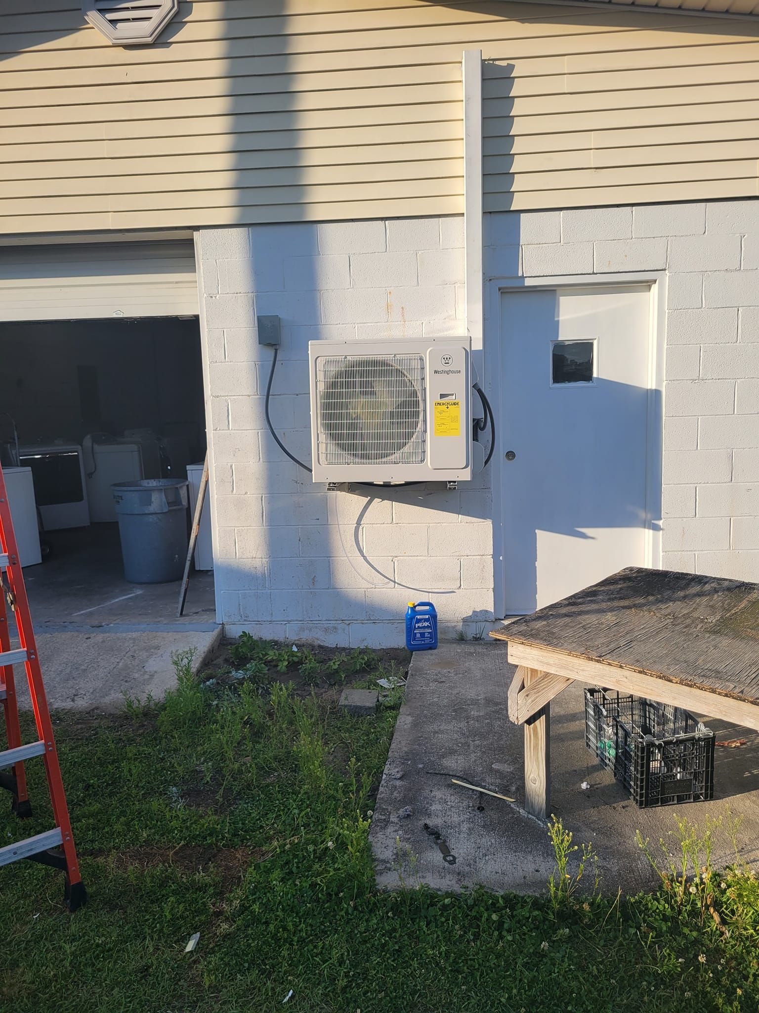 A mitsubishi electric air conditioner is sitting on a brick wall