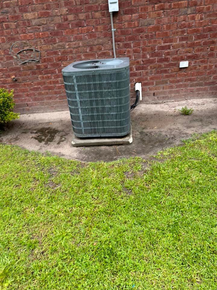 A white thermostat is hanging on a brown wall.