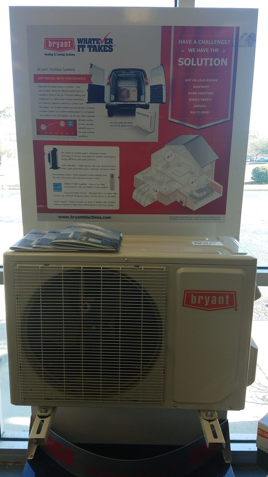 A dryer is sitting in front of a window next to a sign