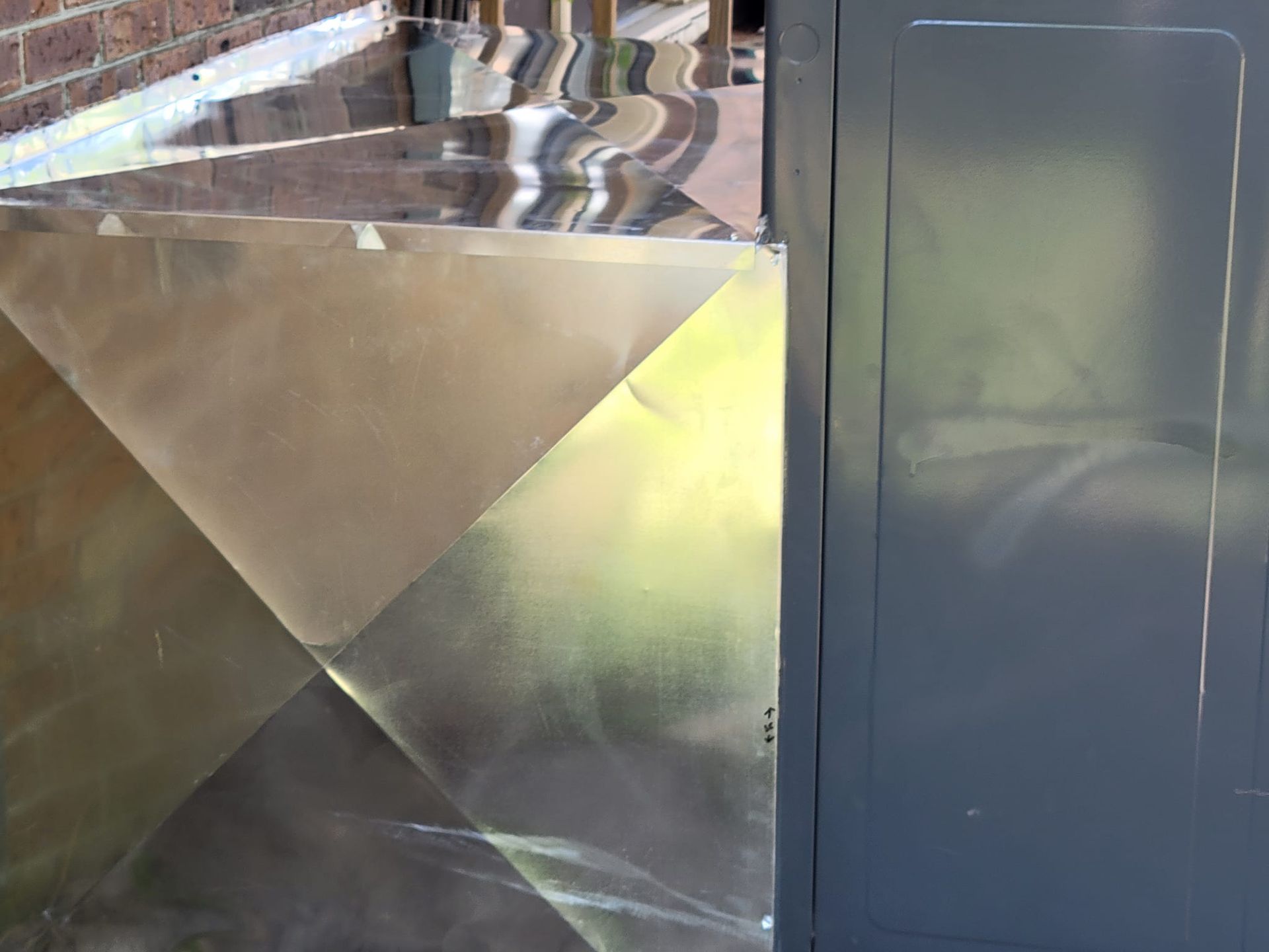 A close up of a metal fence with a brick wall in the background