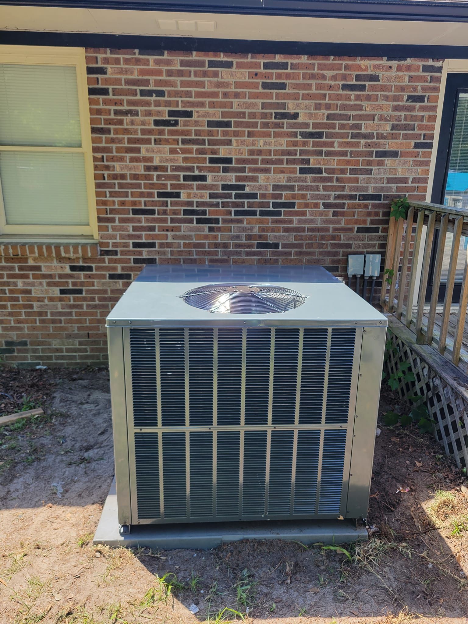 An air conditioner is sitting on the side of a brick building