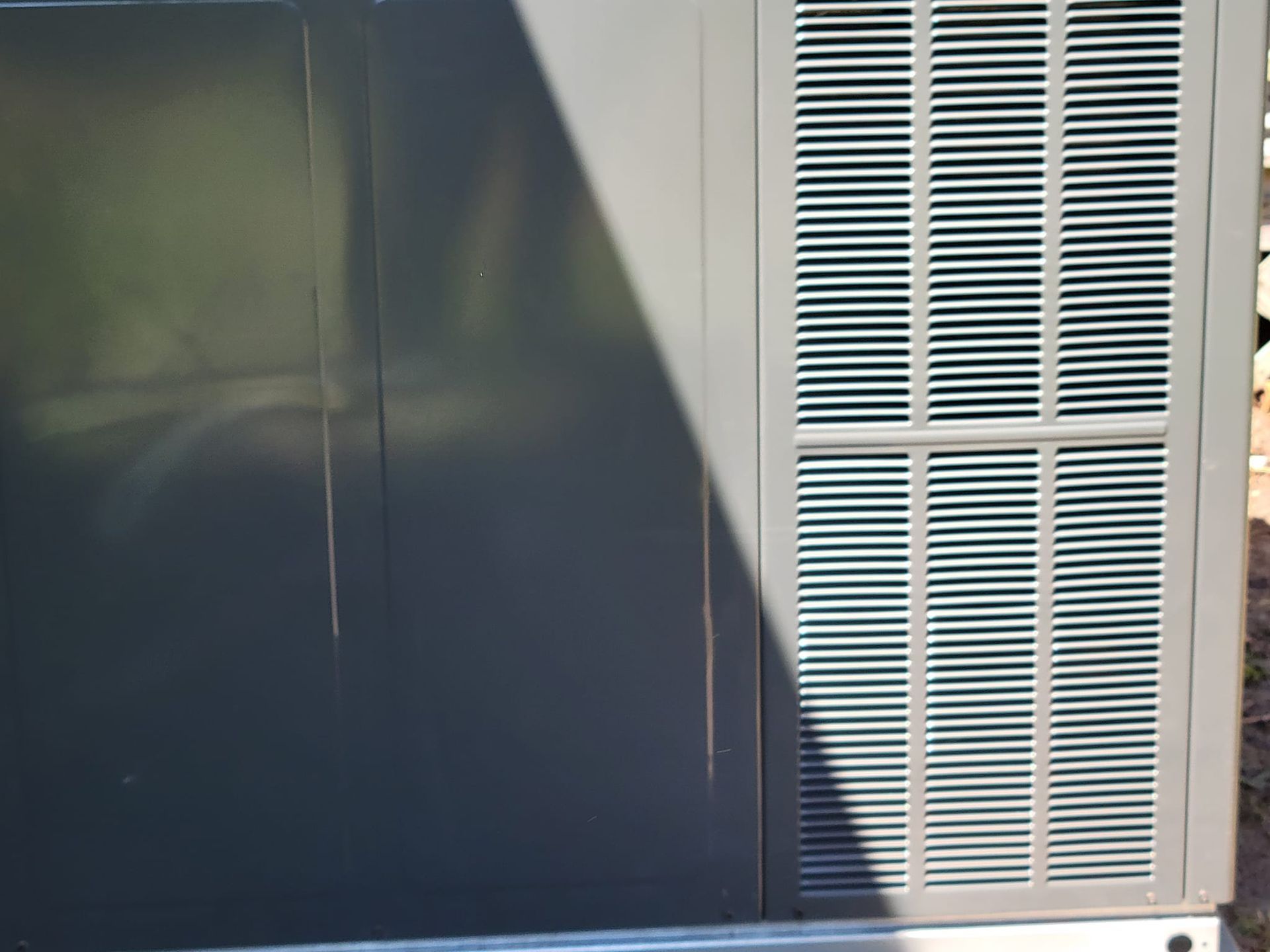 A close up of an air conditioner with a shadow on it