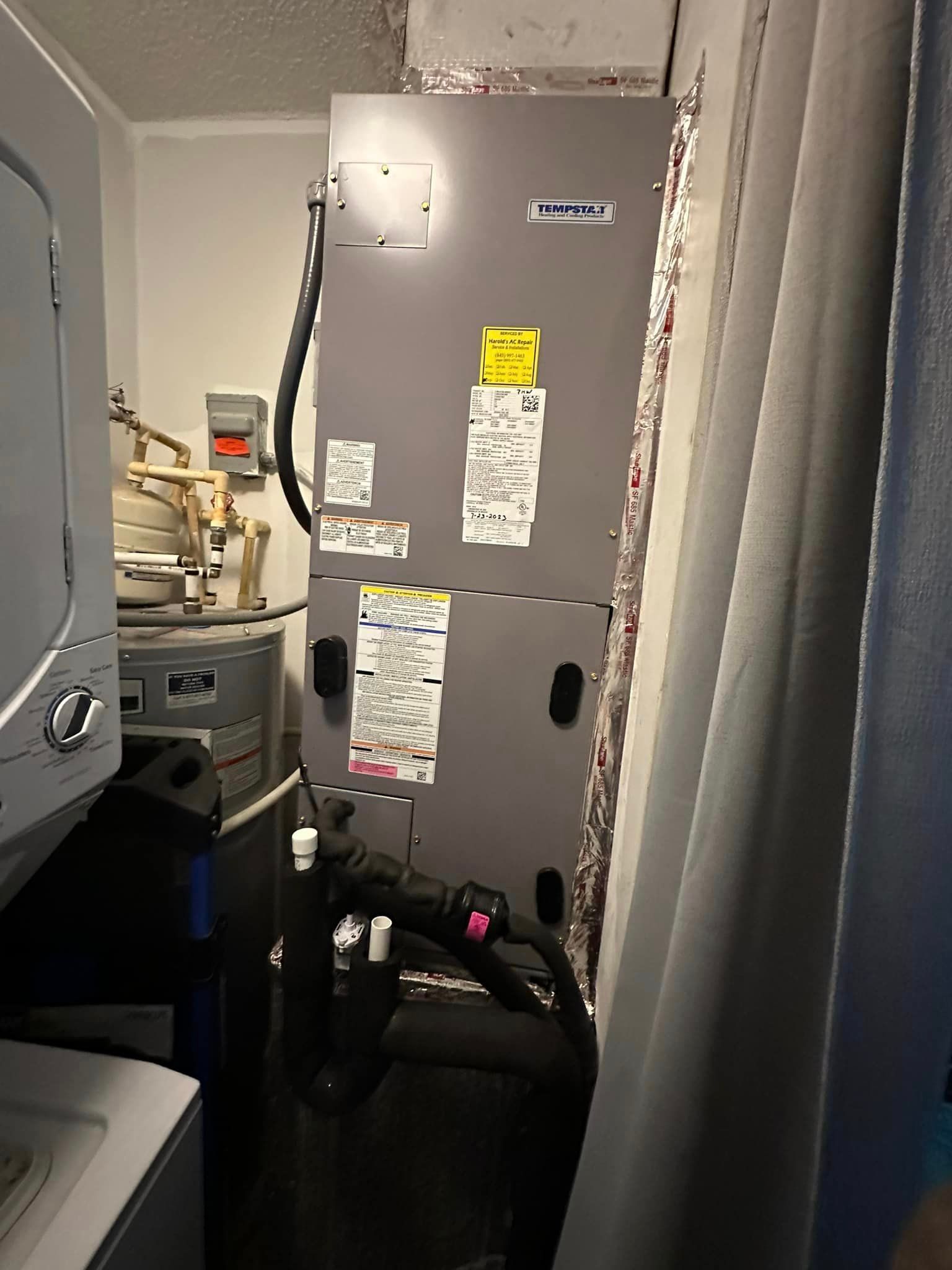 A laundry room with a washer and dryer and an air conditioner