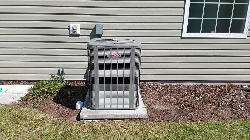 An air conditioner is sitting on the side of a house