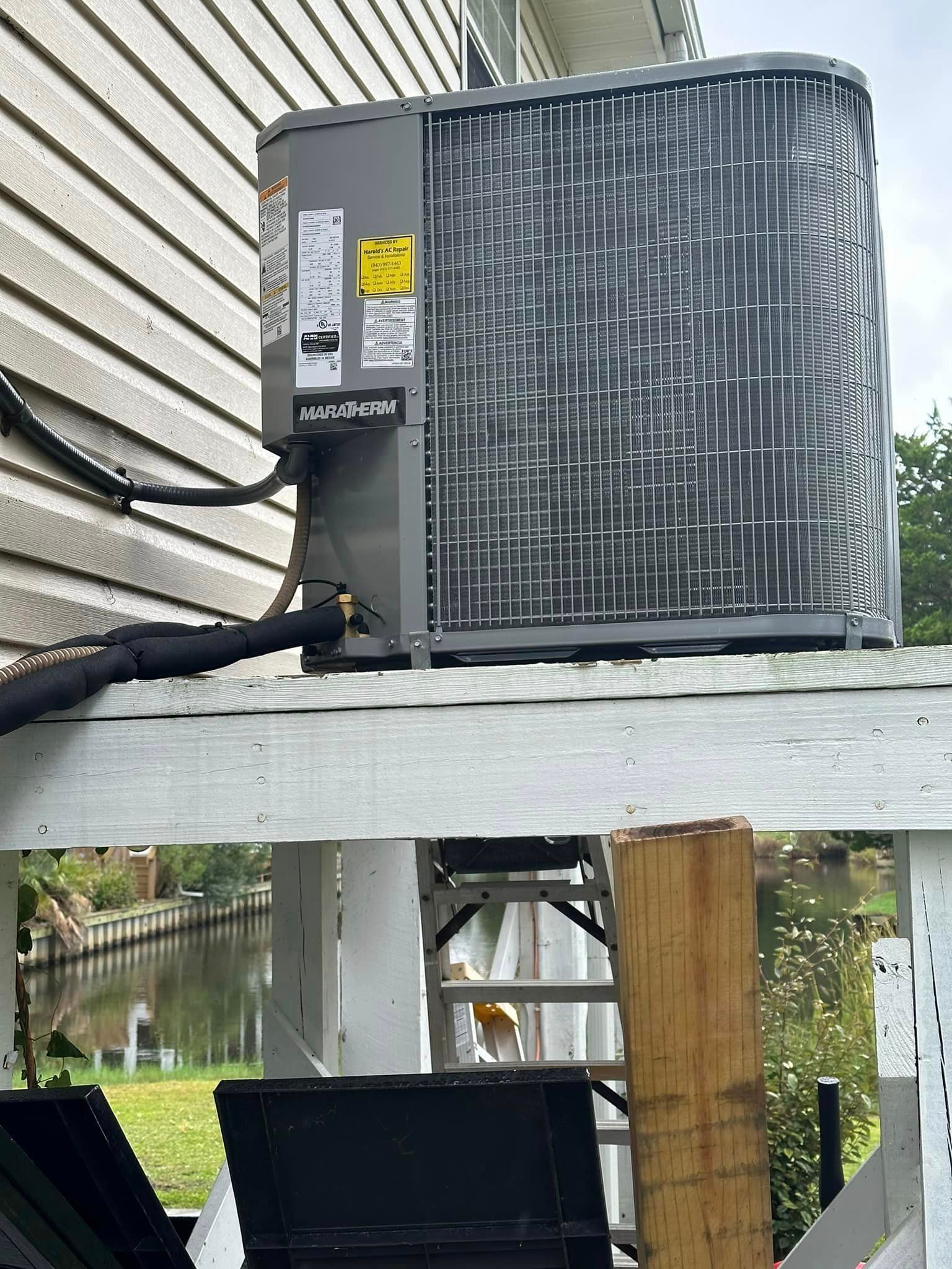 A large air conditioner is mounted on the side of a house