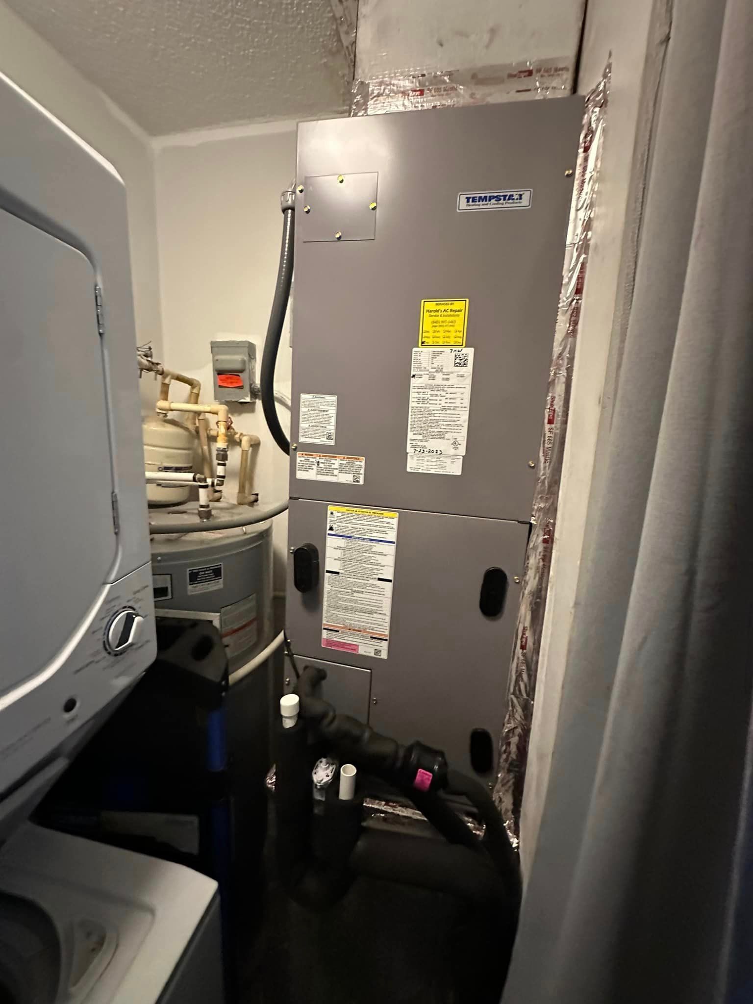 A laundry room with a washer and dryer and a heater