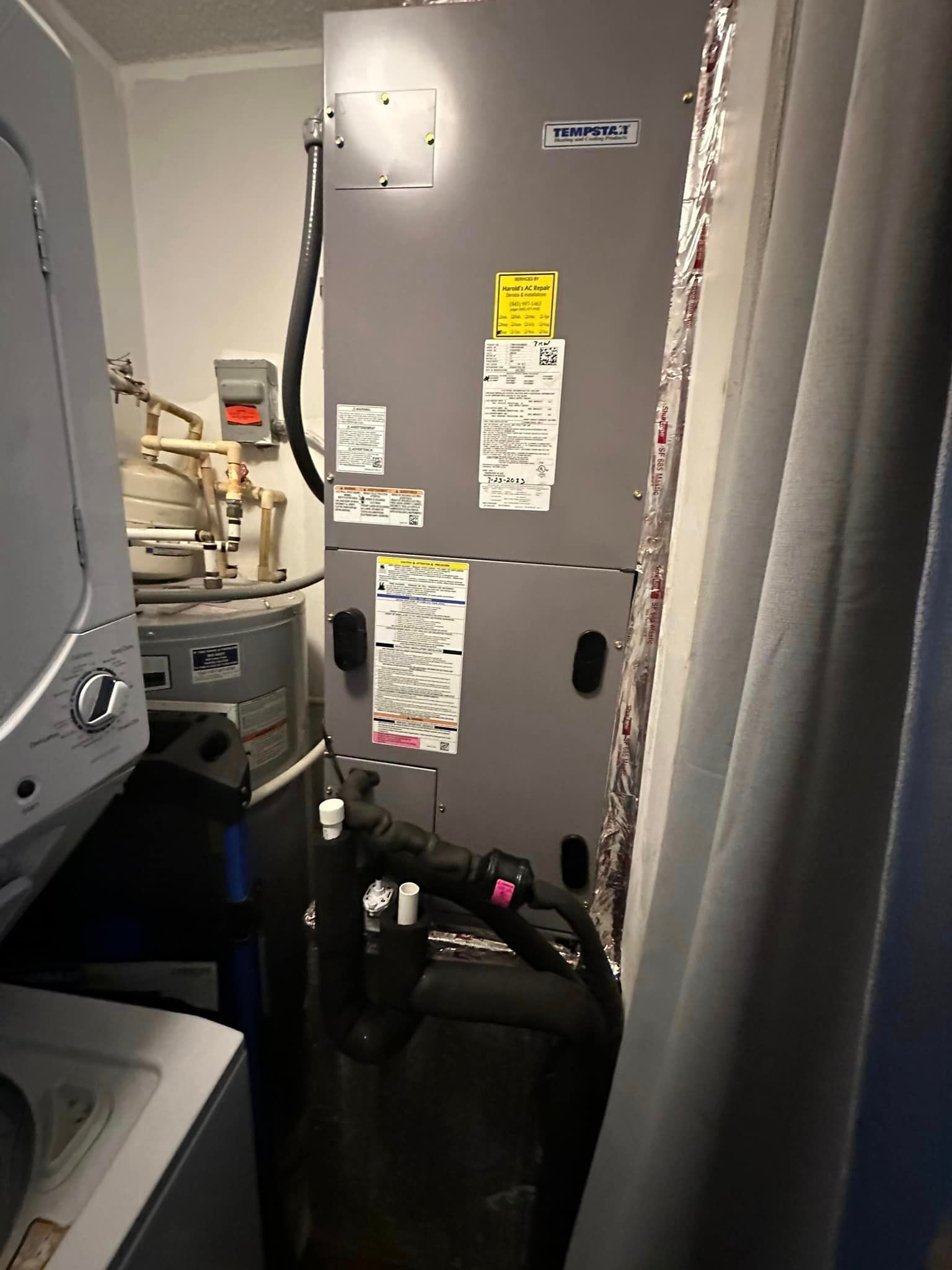 A laundry room with a washer and dryer and an air conditioner