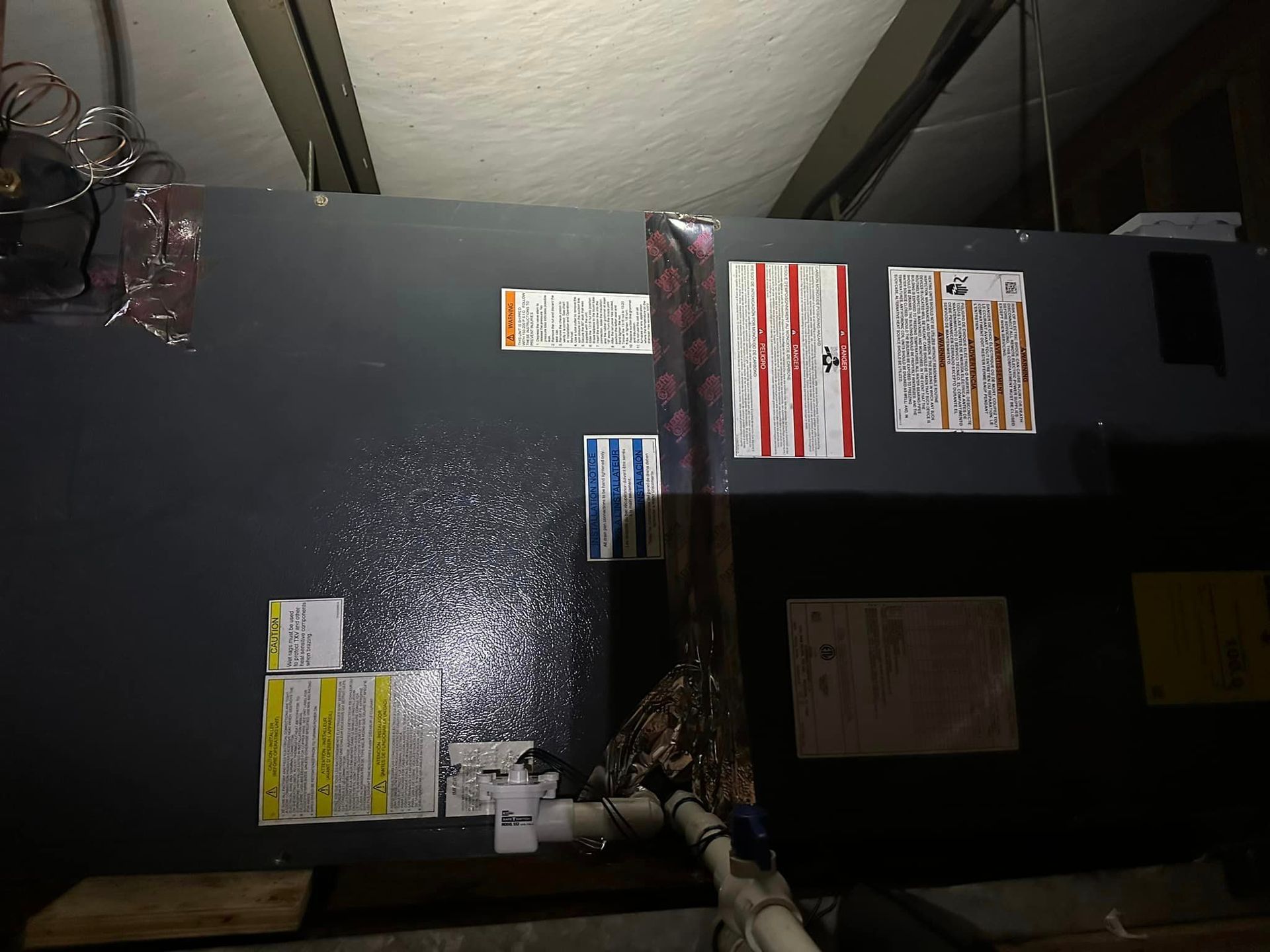 A wall with a lot of stickers on it in a dark room.