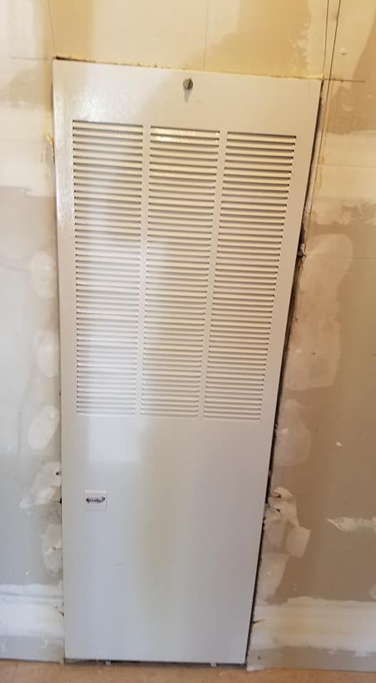 A white door is hanging on a wall in a room