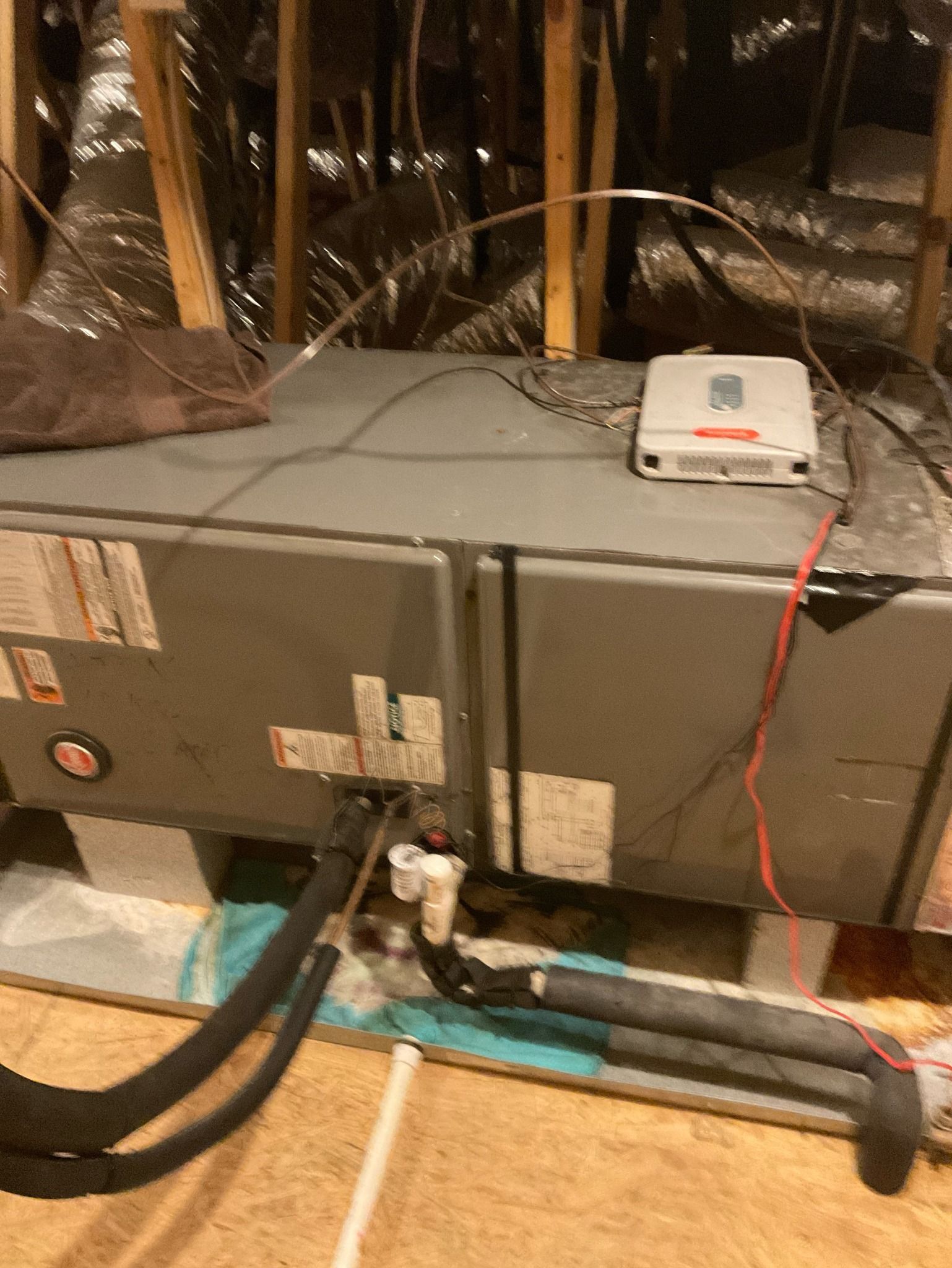 A box with wires coming out of it is sitting on the floor.