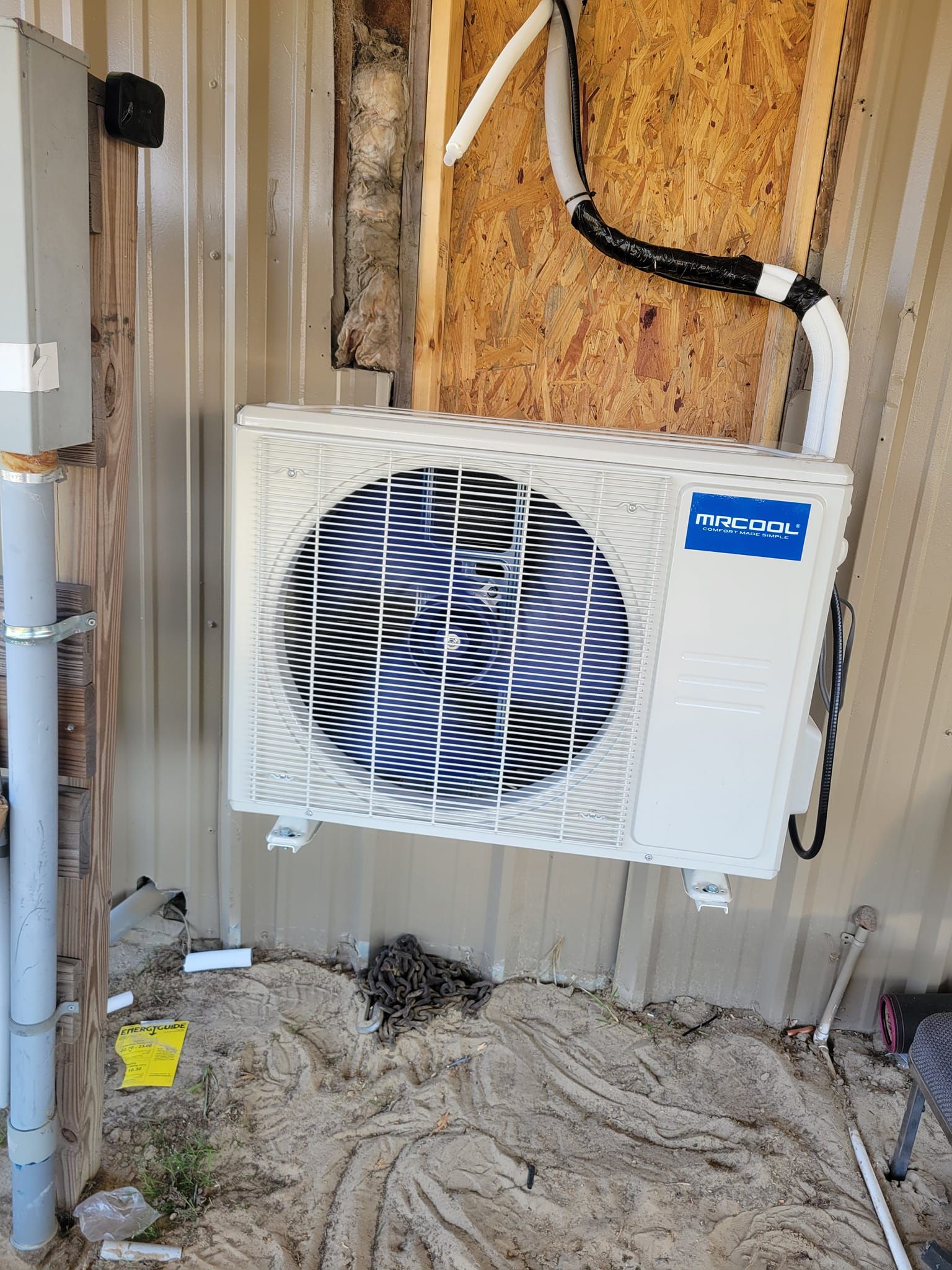 A white and blue air conditioner is mounted on the side of a building