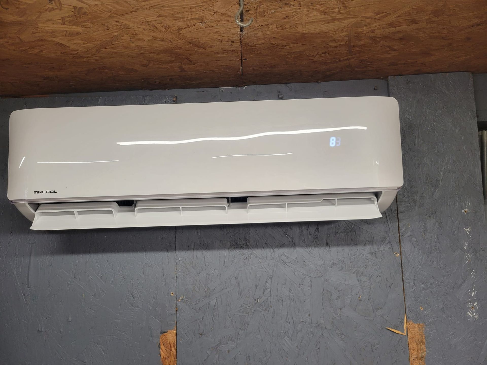 A white air conditioner is hanging on a wall