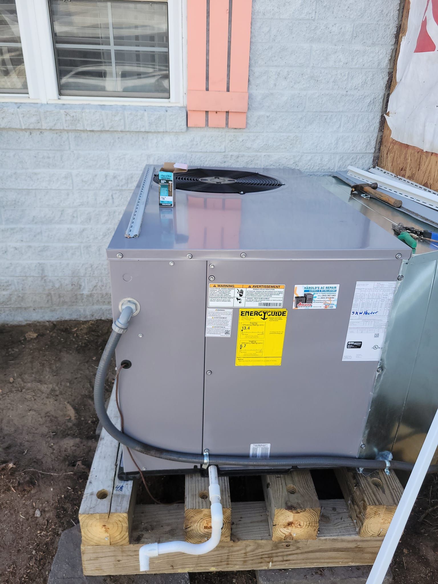 An air conditioner is sitting on a wooden pallet 