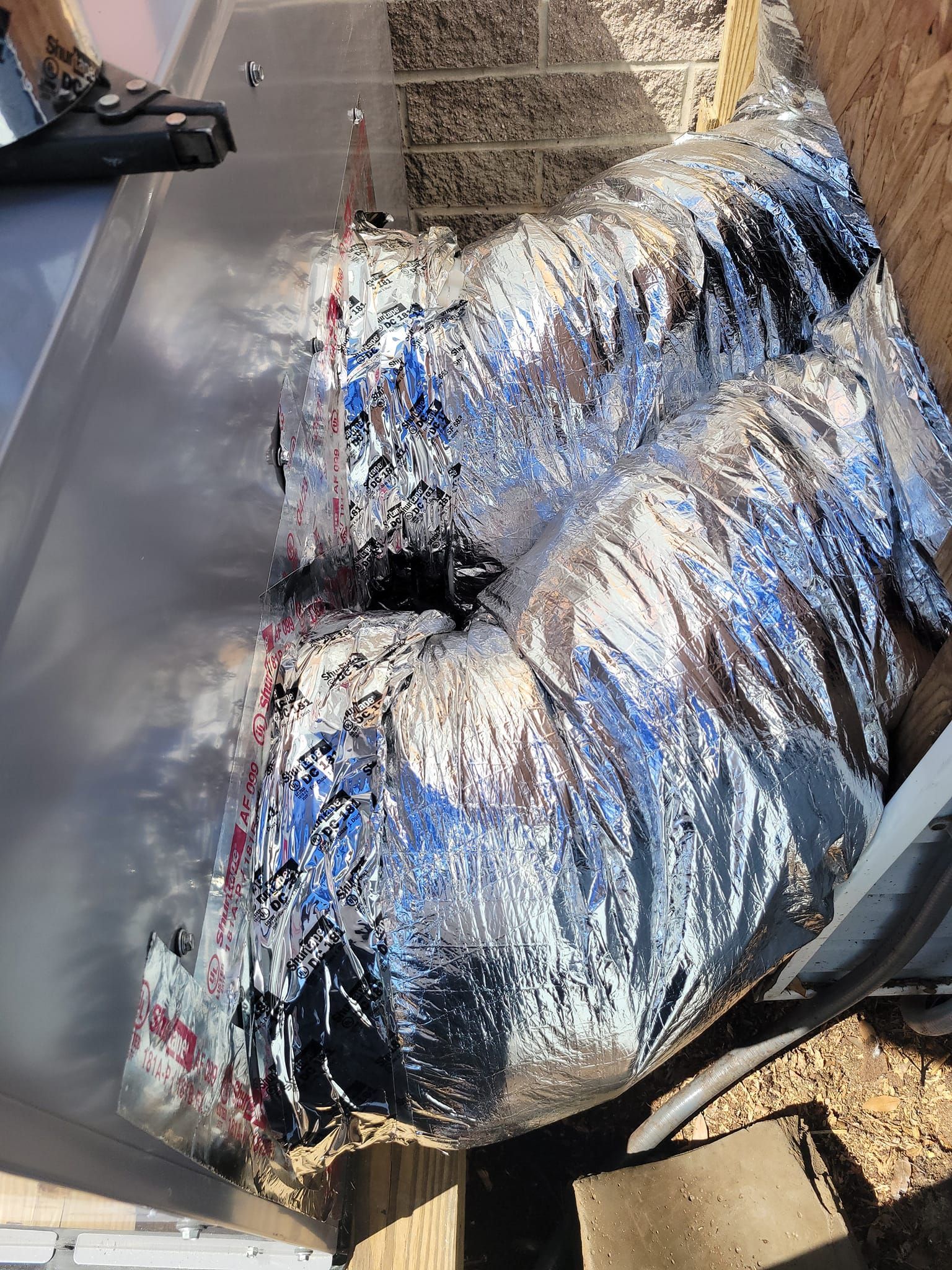 A close up of a duct with aluminum foil on it