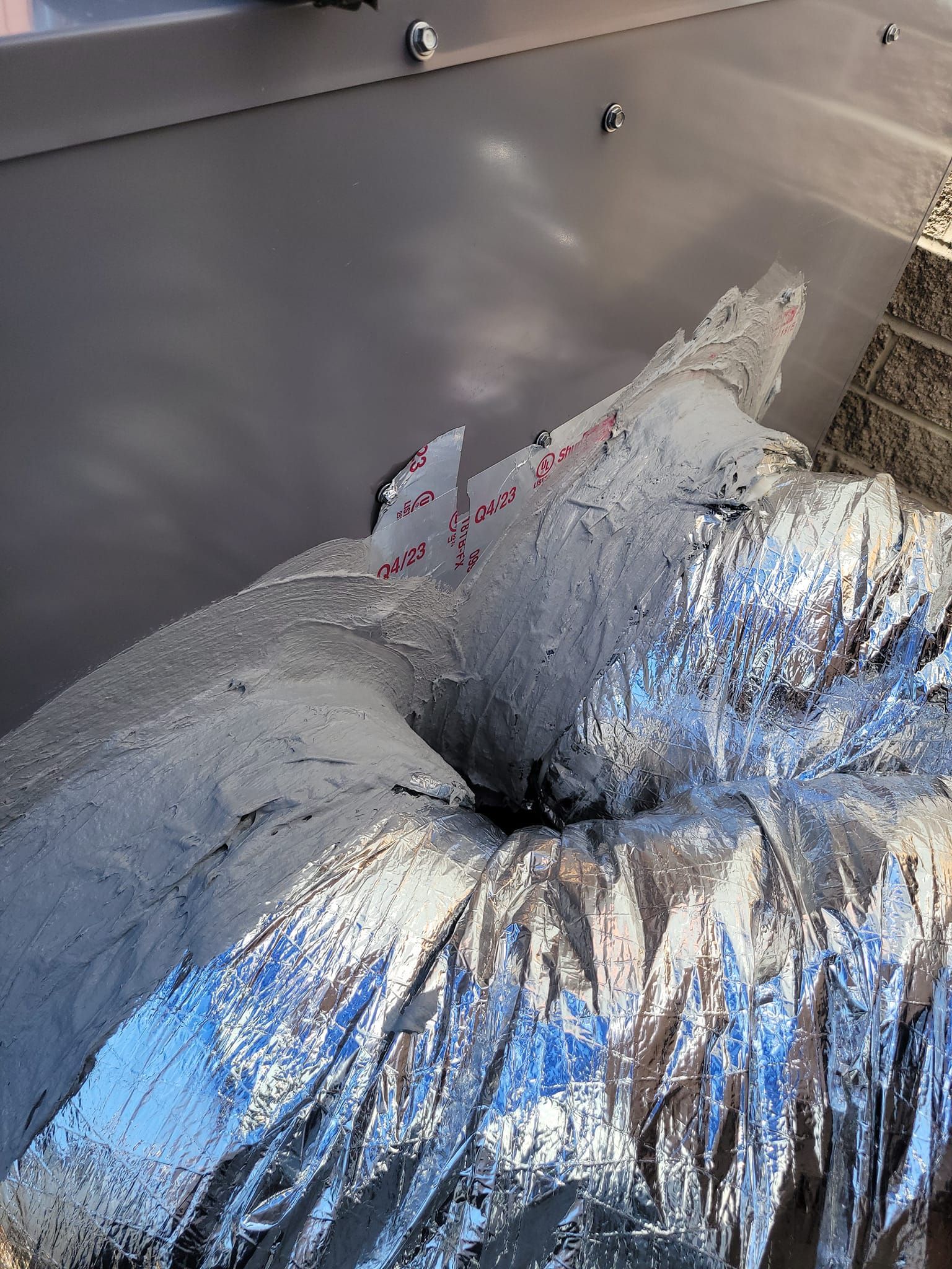 A close up of a metal pipe covered in aluminum foil