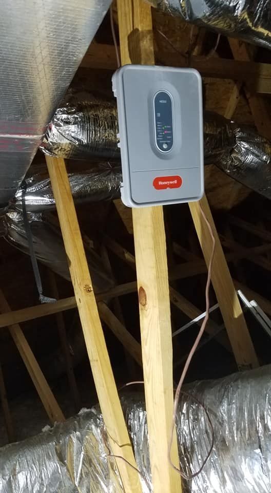 A thermostat is hanging from the ceiling of a house