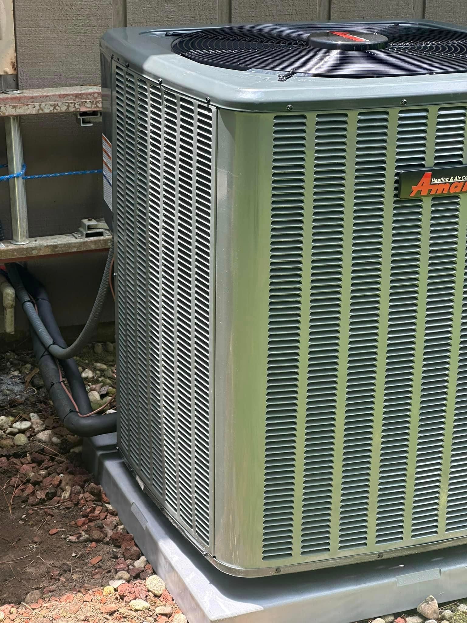 A large air conditioner is sitting on top of a concrete base