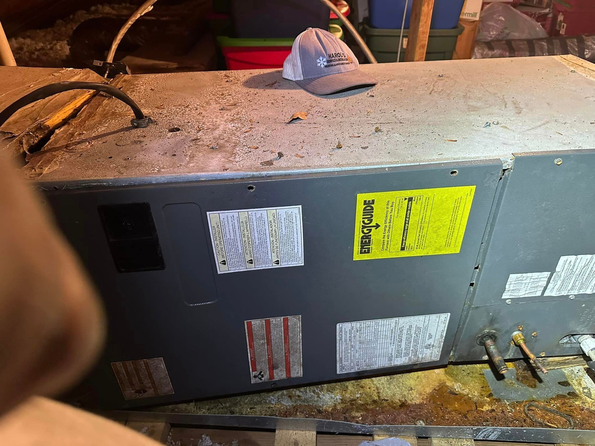 A hat is sitting on top of a dirty air conditioner