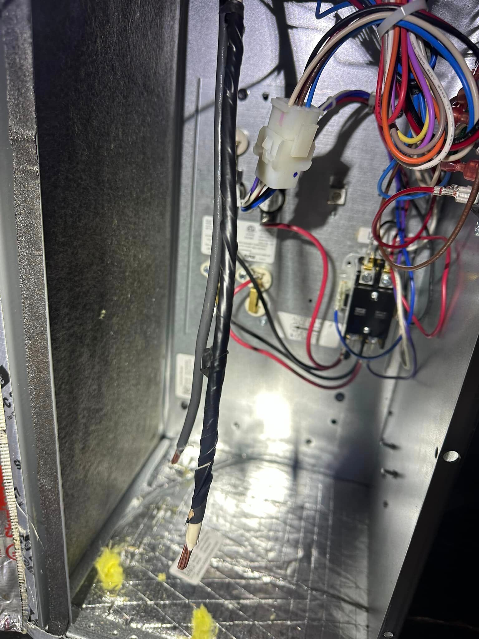 The inside of a refrigerator with a lot of wires coming out of it