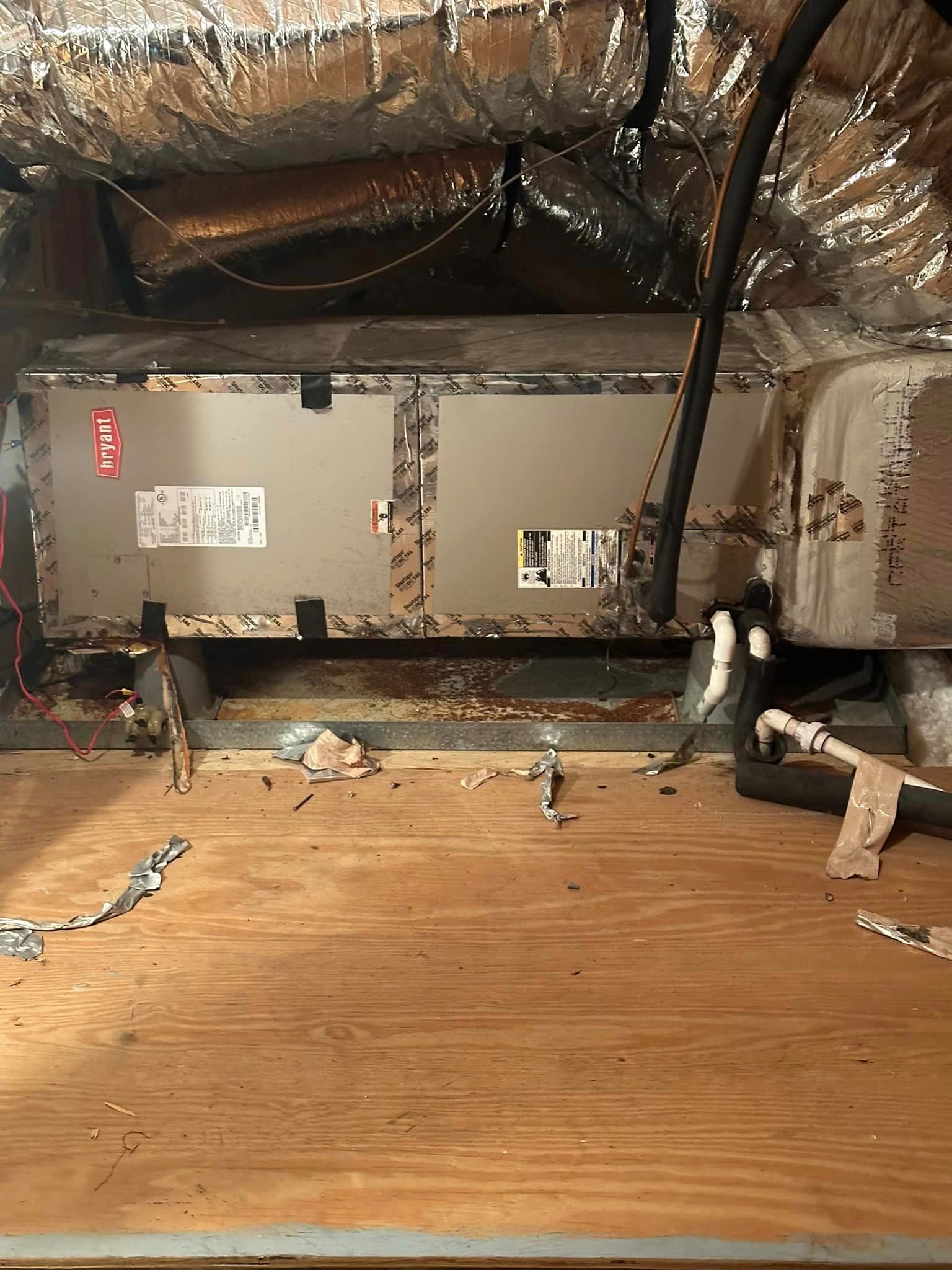 A dirty air conditioner is sitting on top of a wooden floor.