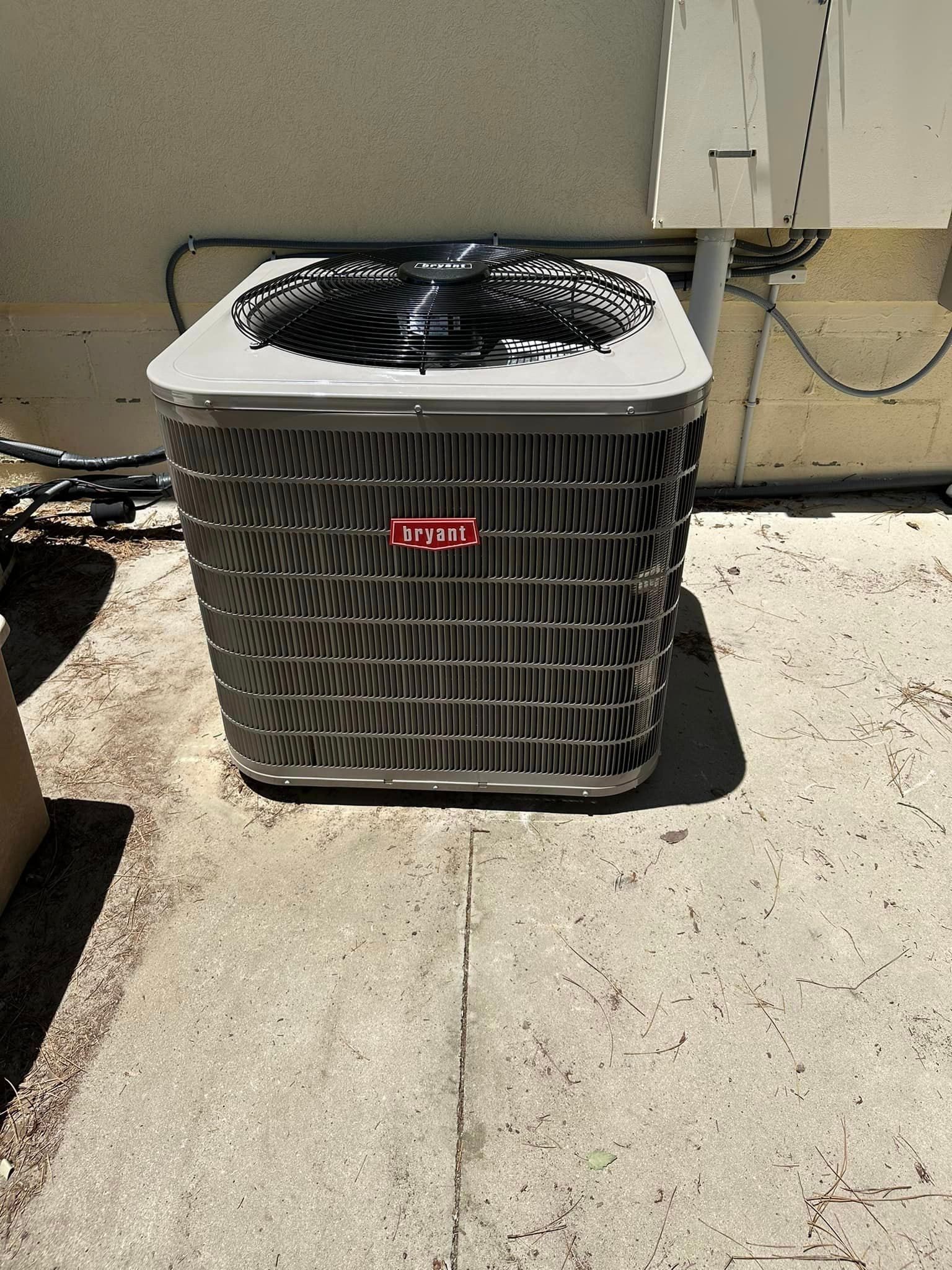A large air conditioner is sitting on the ground outside of a building