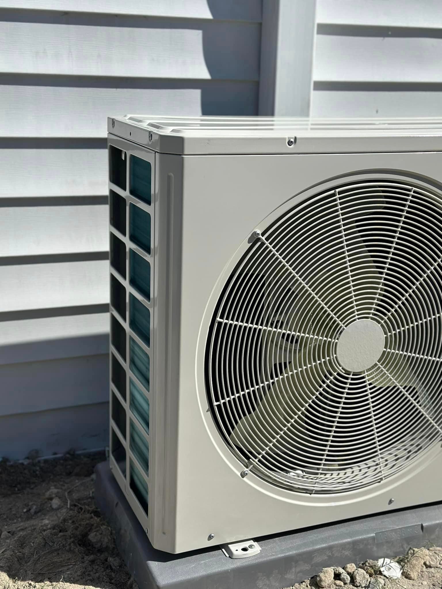 A large fan is sitting on the ground in front of a building