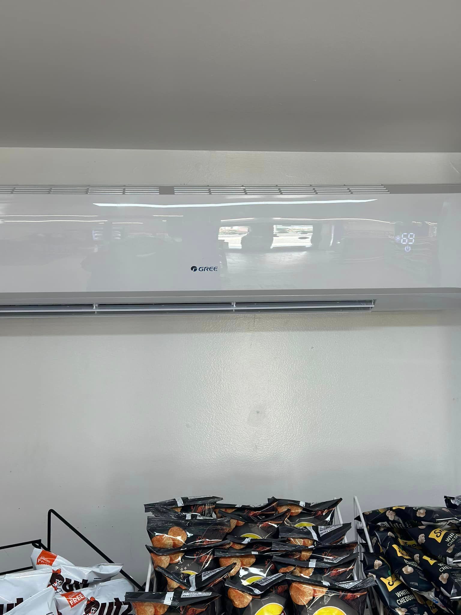 A white air conditioner is hanging from the ceiling in a room