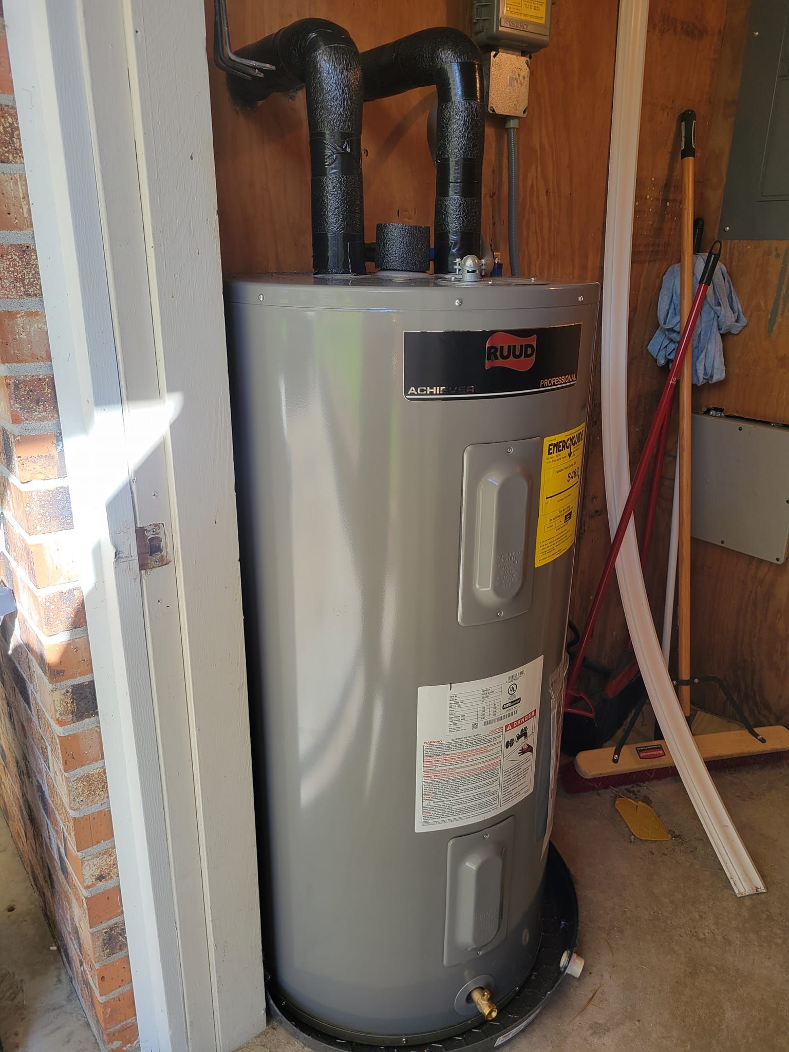 A water heater is sitting in a room next to a door