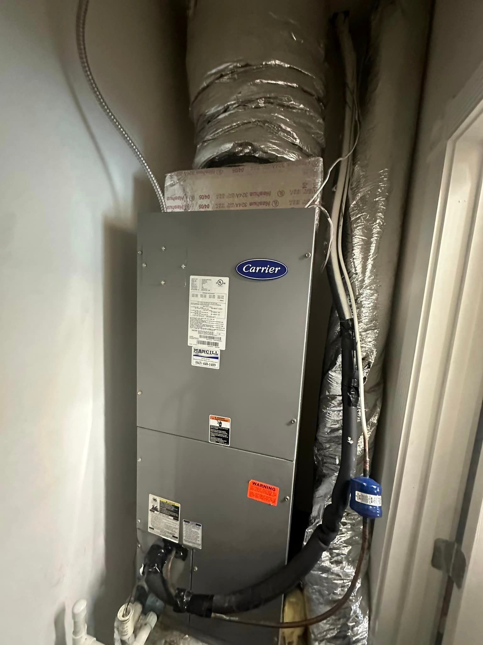 A large air conditioner is hanging from the ceiling of a room