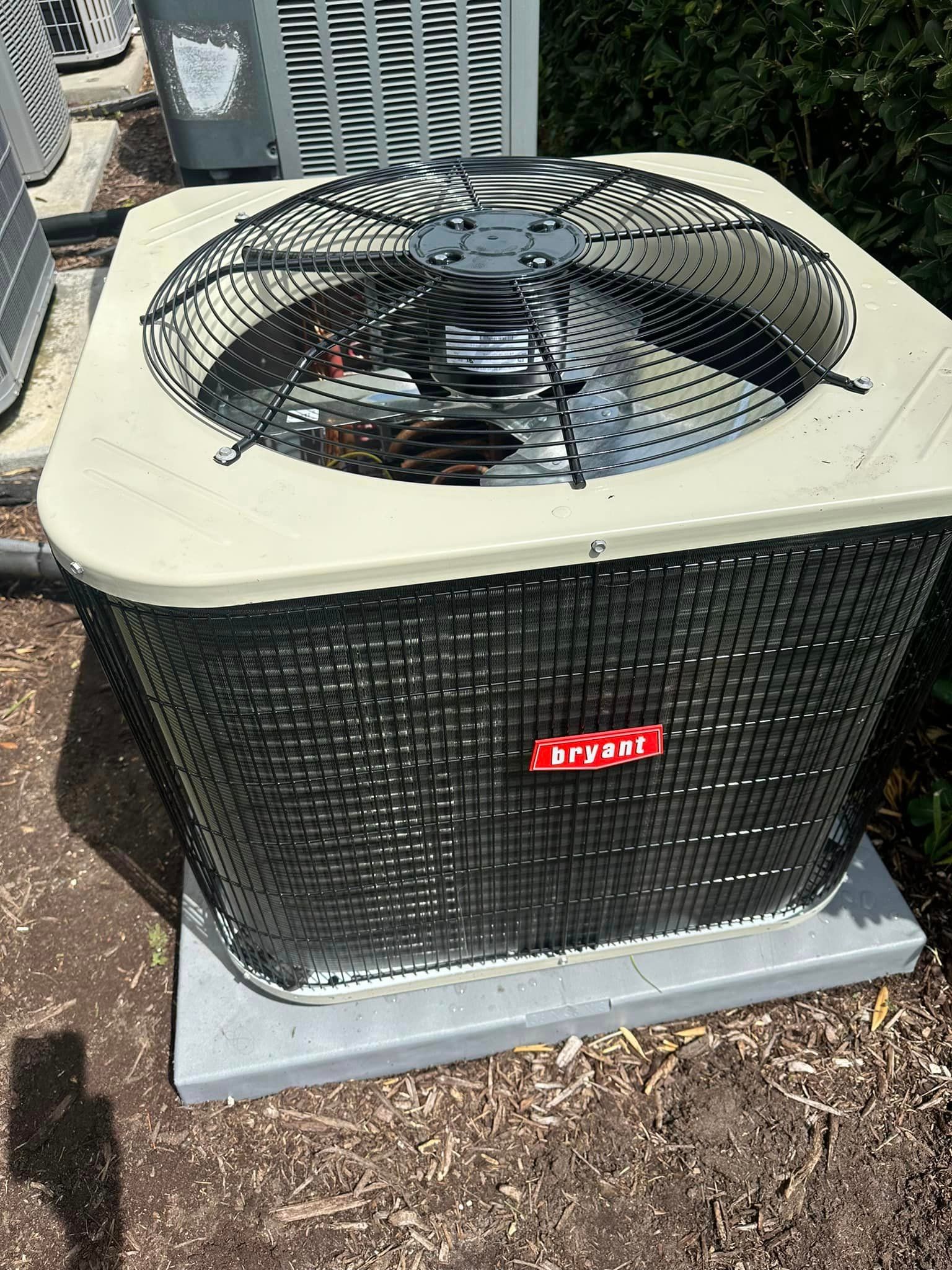 A black and white air conditioner is sitting on the ground