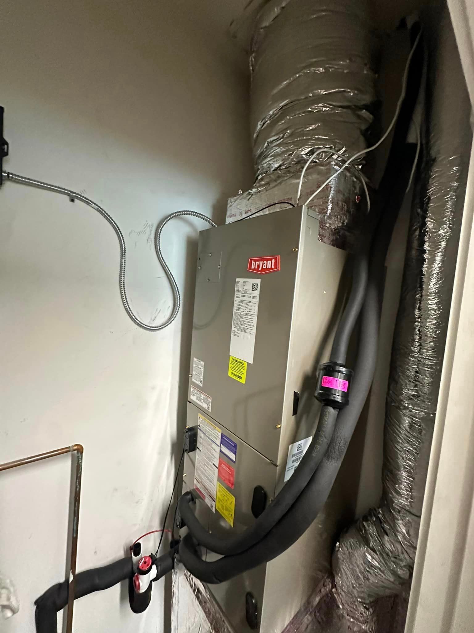 A picture of an air conditioner in a room with a lot of wires coming out of it.