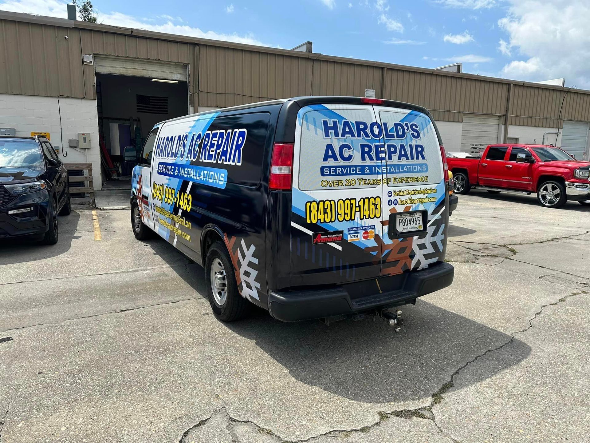 A Harold's  Ac repair van is parked in front of a building