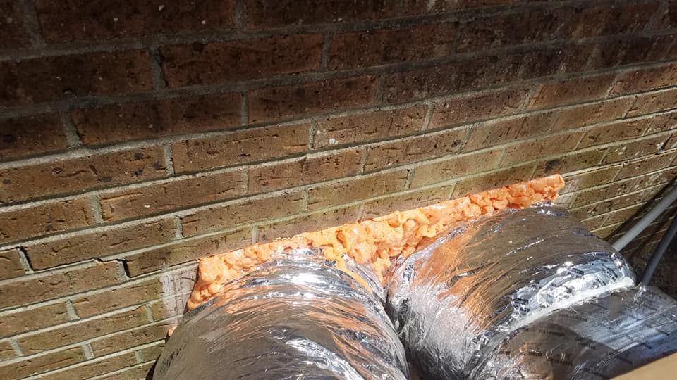 A close up of a duct on a brick wall