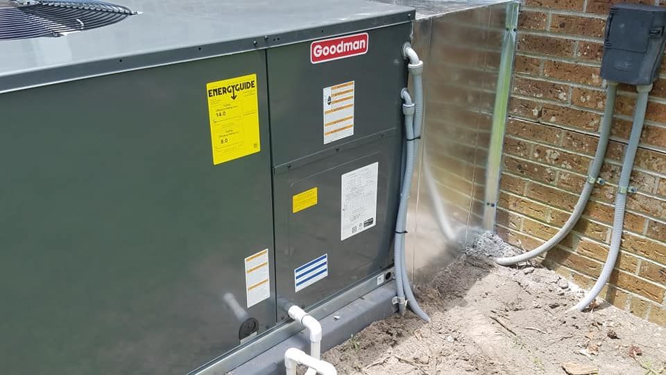 A large air conditioner is sitting next to a brick wall