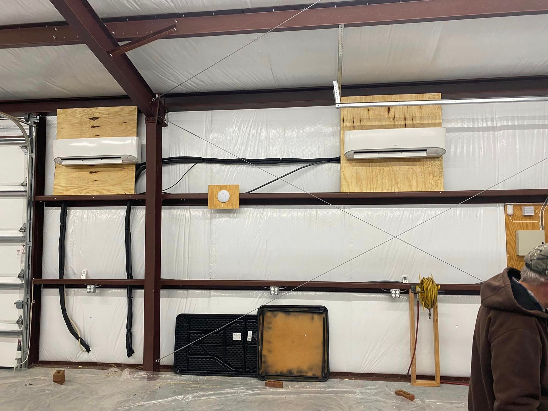 A man is standing in a building with a lot of wires hanging from the ceiling