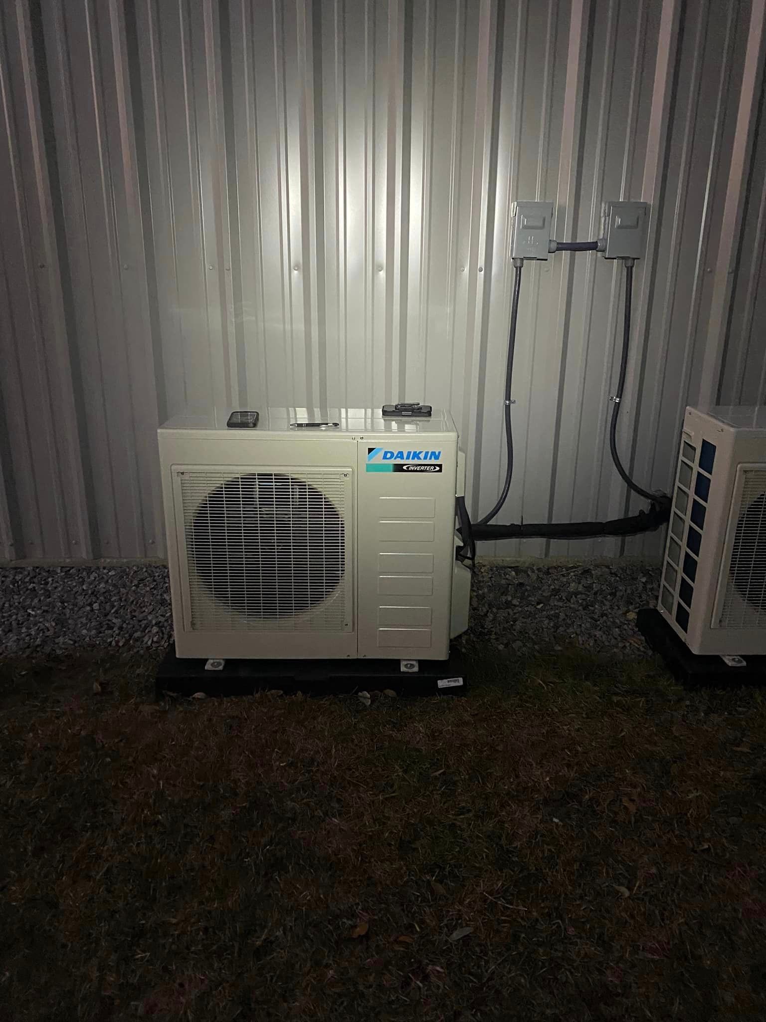 Two air conditioners are sitting outside of a building