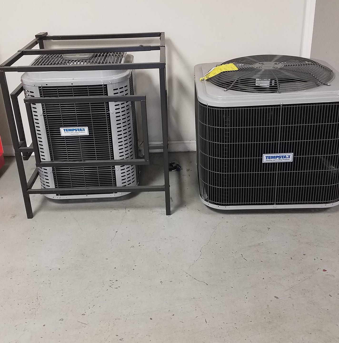 Two air conditioners are sitting next to each other on the floor