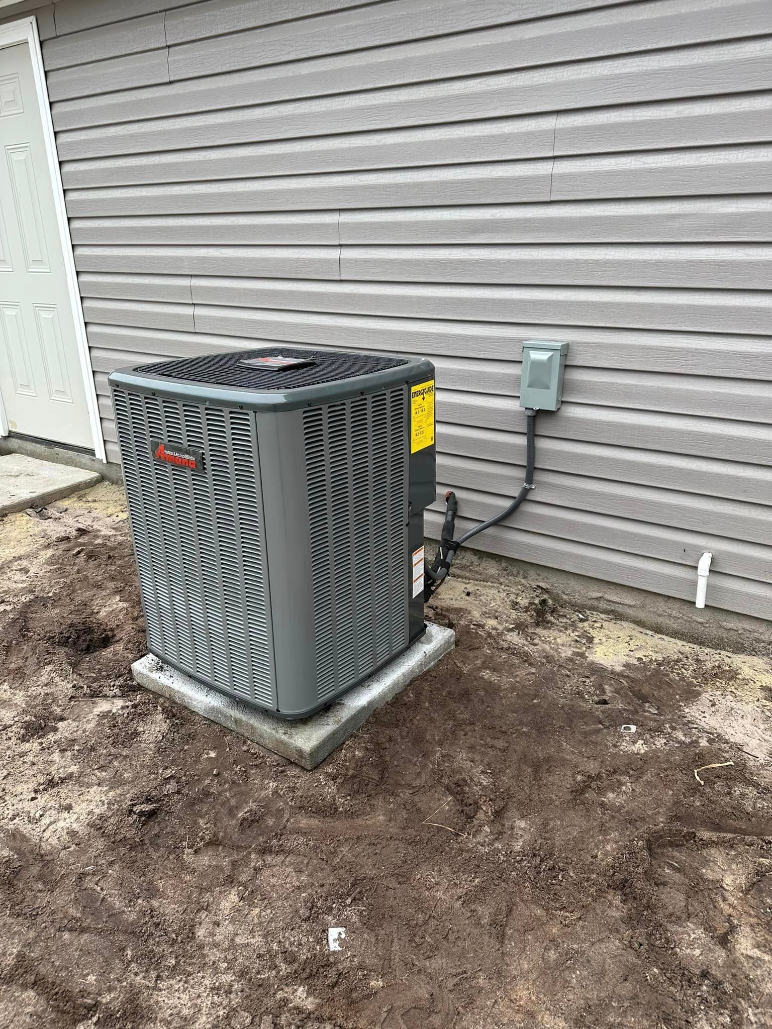 An air conditioner is sitting on the side of a house