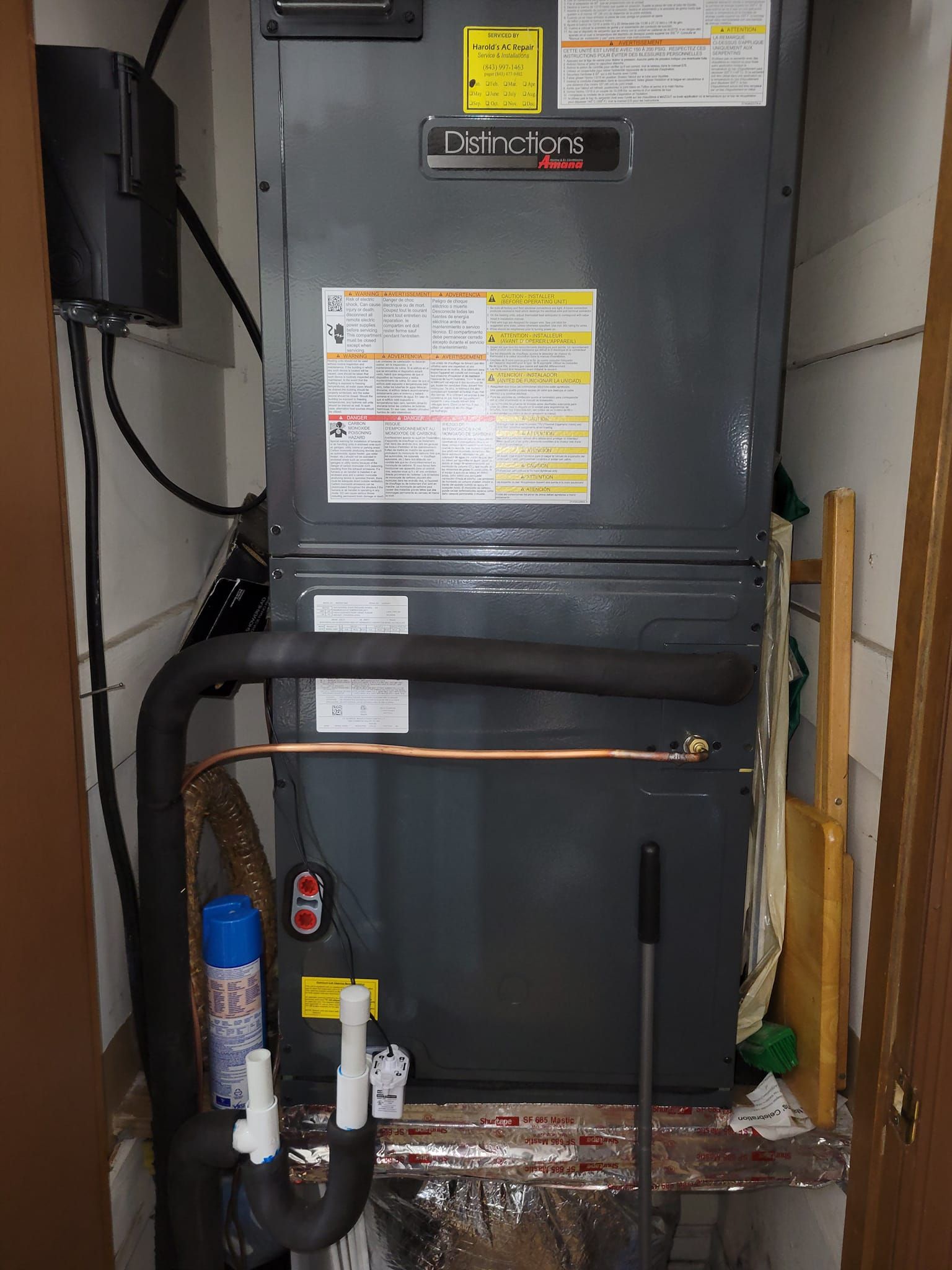 An air conditioner is sitting in a corner of a room next to a door