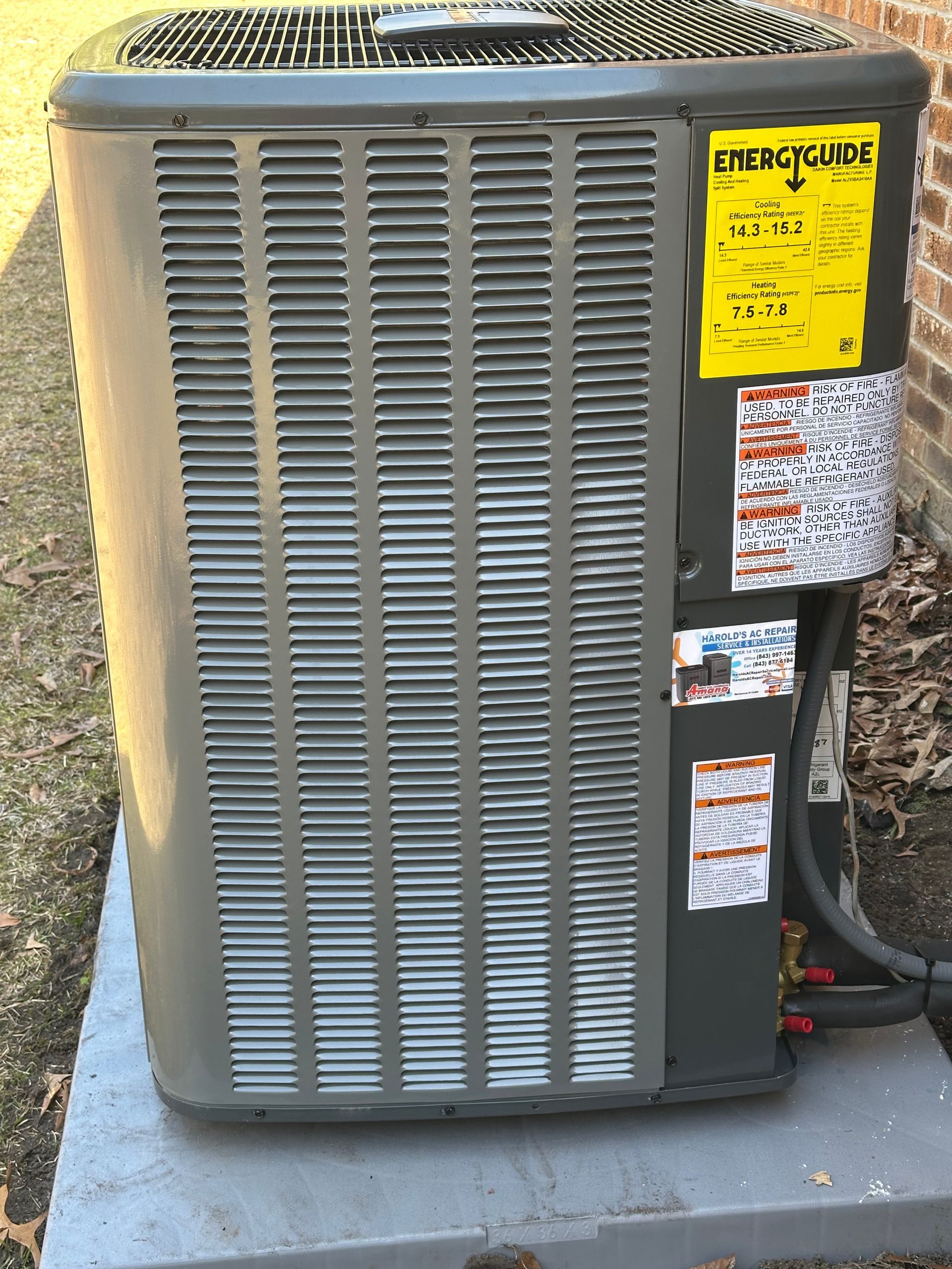 A large air conditioner is sitting on top of a concrete platform.