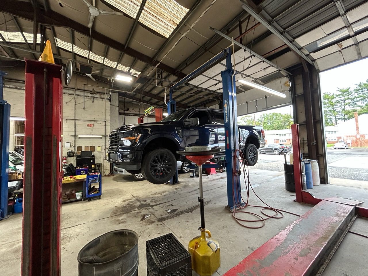 Black SUV lifted on a hydraulic hoist in an auto repair garage