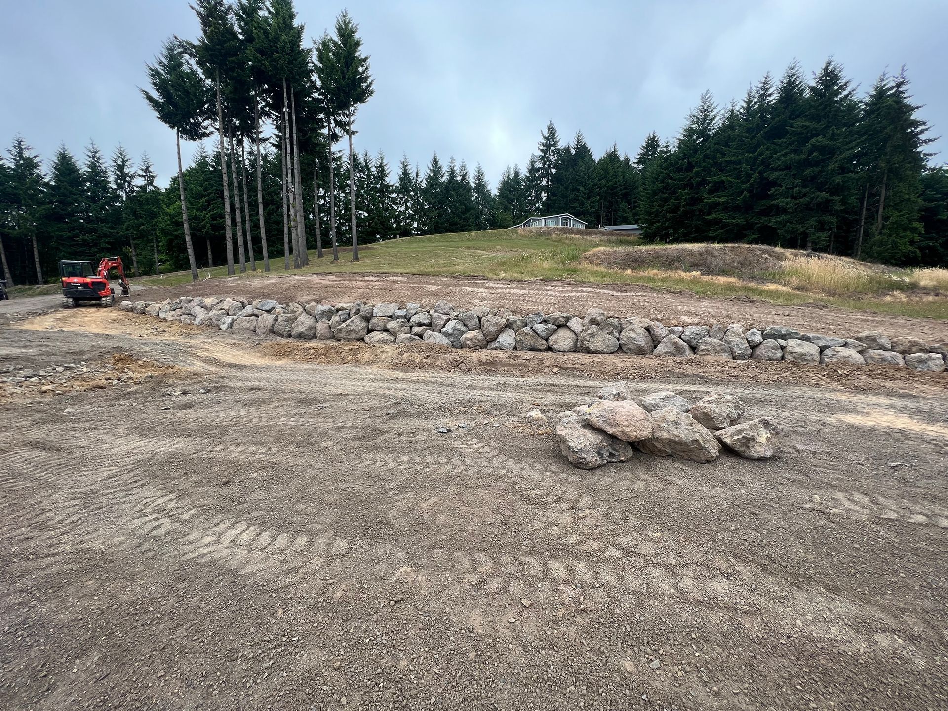 a large rock wall is being built in a dirt field