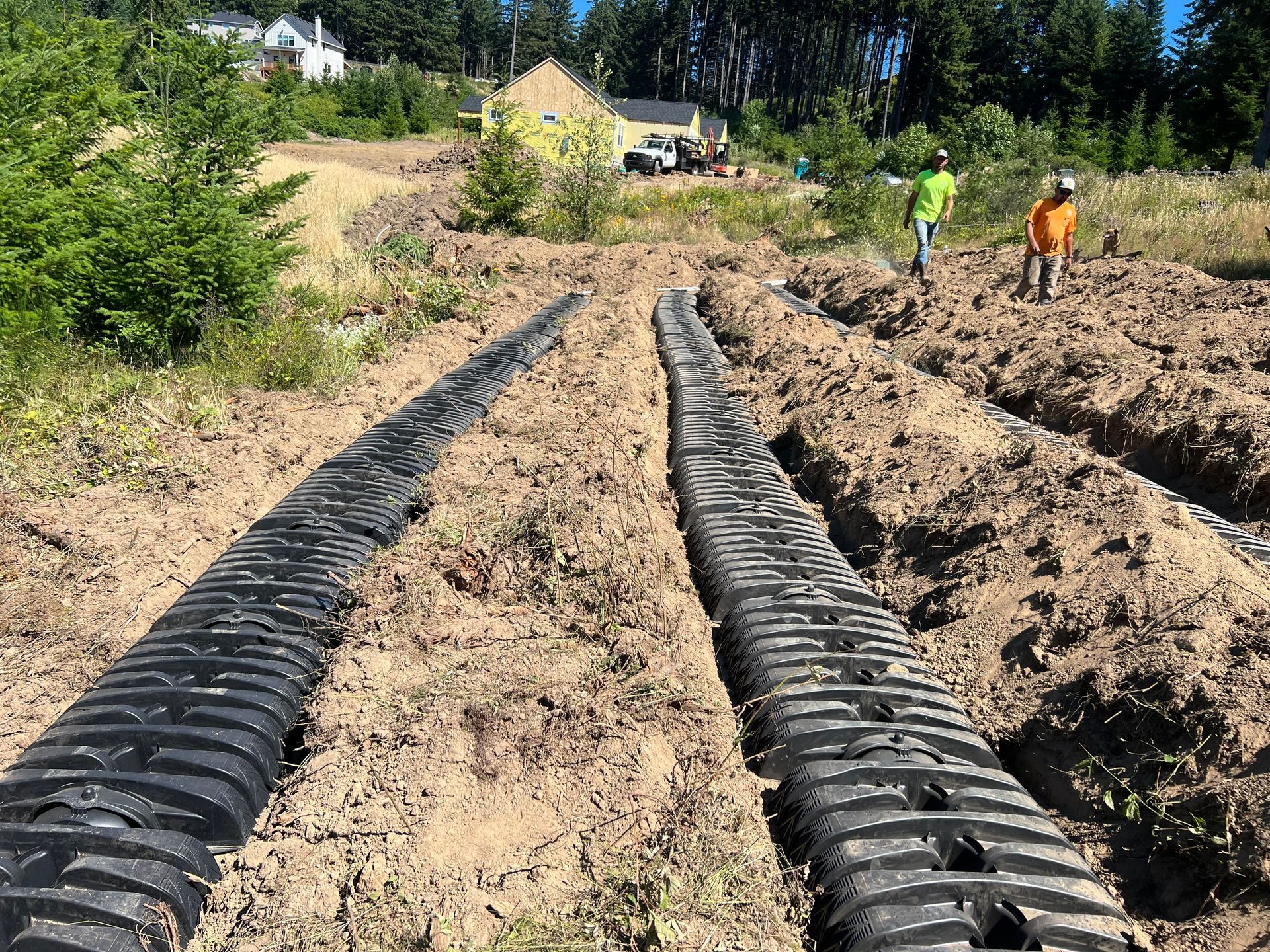 a couple of people are standing in the dirt next to a large pipe
