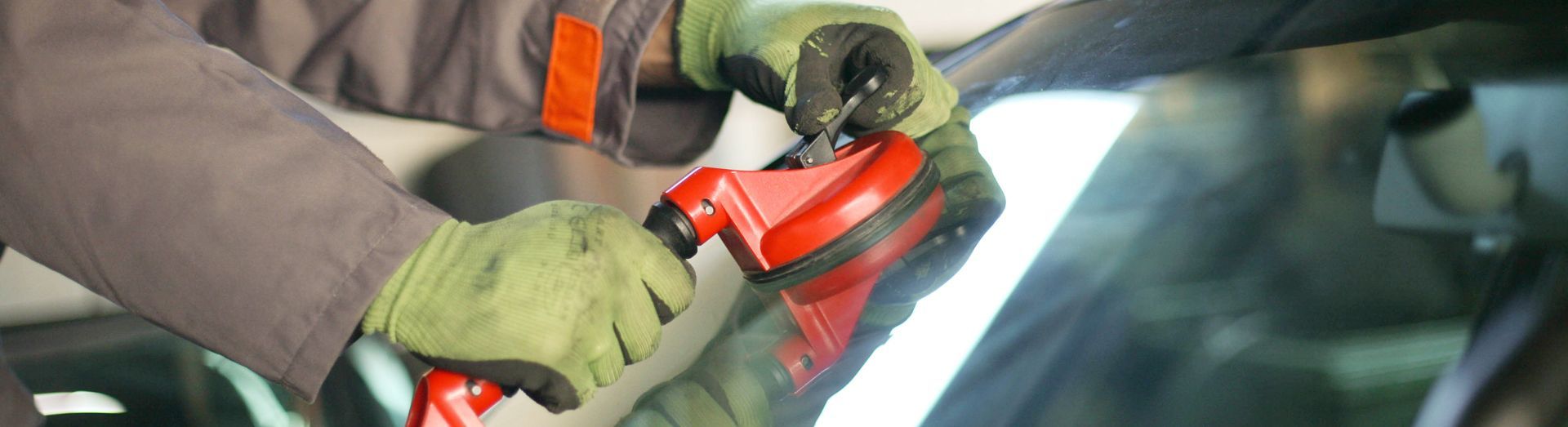 Mechanic changing glass on car in his workshop