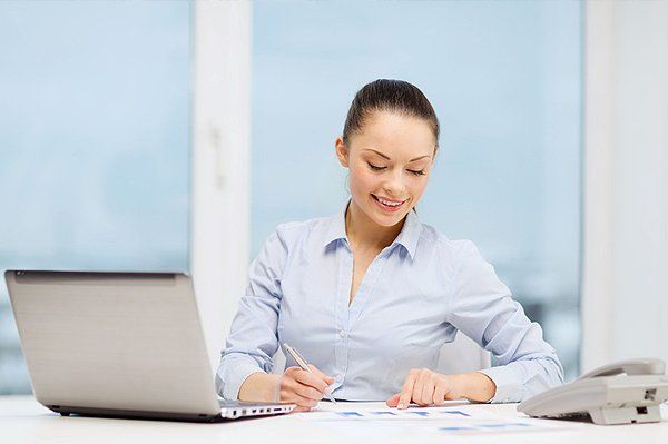 Accountant with phone, laptop and files in office