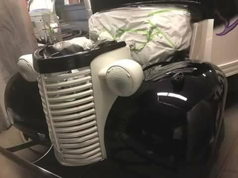 A black and white car is sitting in a garage.